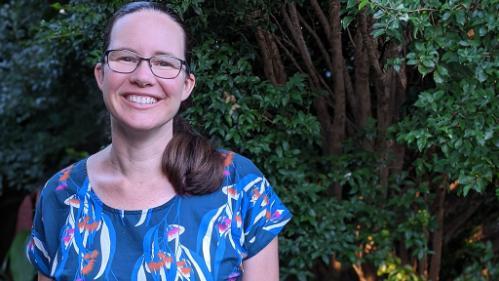 Alison Mellor stands in front of shrubbery