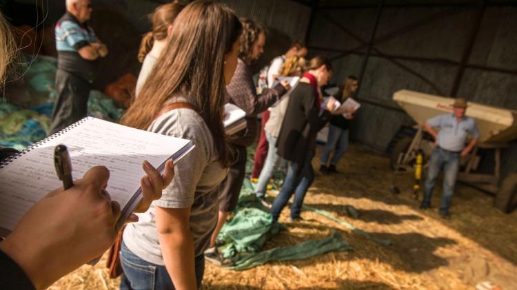 SGSC students standing writing notes on a field trip