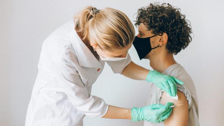 Young male getting vaccinated by nurse