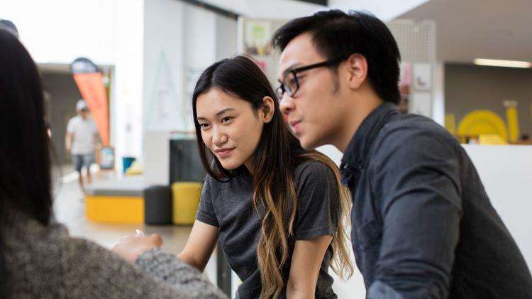 Man and woman having a discussion with another person on Wollongong campus 