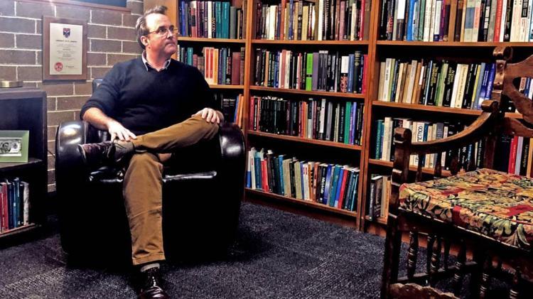 Daniel Hutto sitting on chair in office