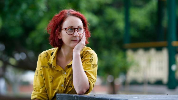 Dr Rachel Loney-Howes sitting at park table