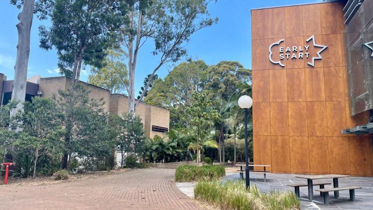 Outside Northfields Psychology Clinic buildings with the Early Start building timber panel sign
