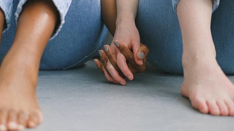 two people holding hands while sitting down