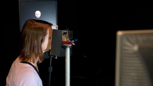 Student looking into machine with reflection