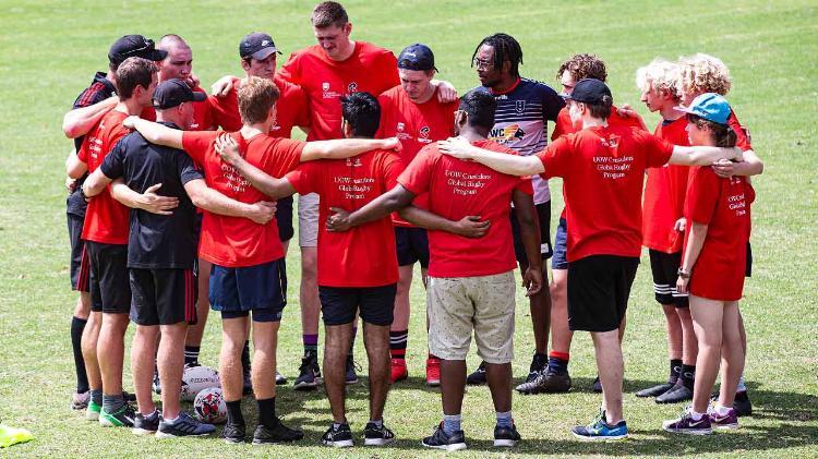 image of team of sportsmen and women hugging