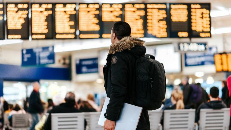 Man carrying laptop walking through terminal