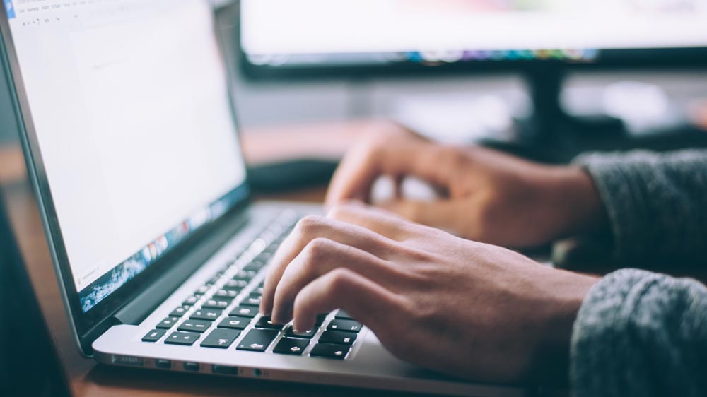 Person typing on keyboard