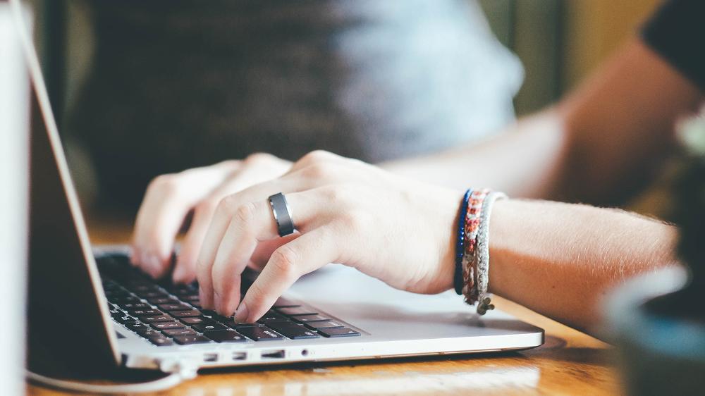 Hands typing at a computer keyboard