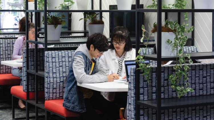 Students sitting at a group table in the refreshed space on the Ground Floor of UOW Library 51 Campus