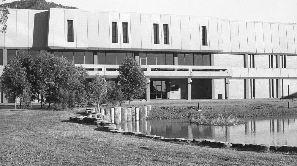 Black and white photograph of the Library building and the duck pond lawn in 1980