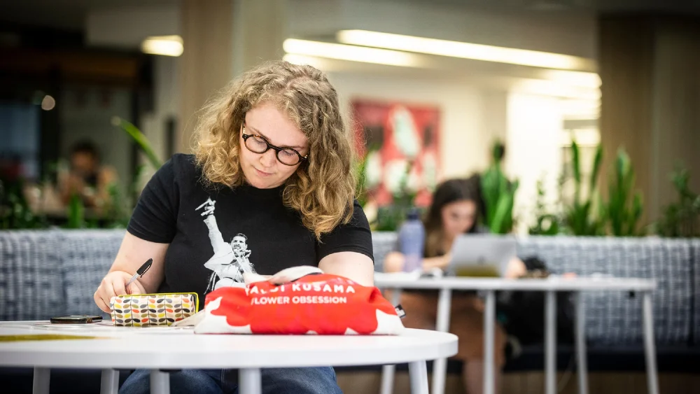 Student sitting at a desk on the ground floor of 51 Campus Library