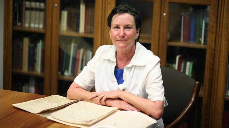 Woman sitting at desk with archival papers