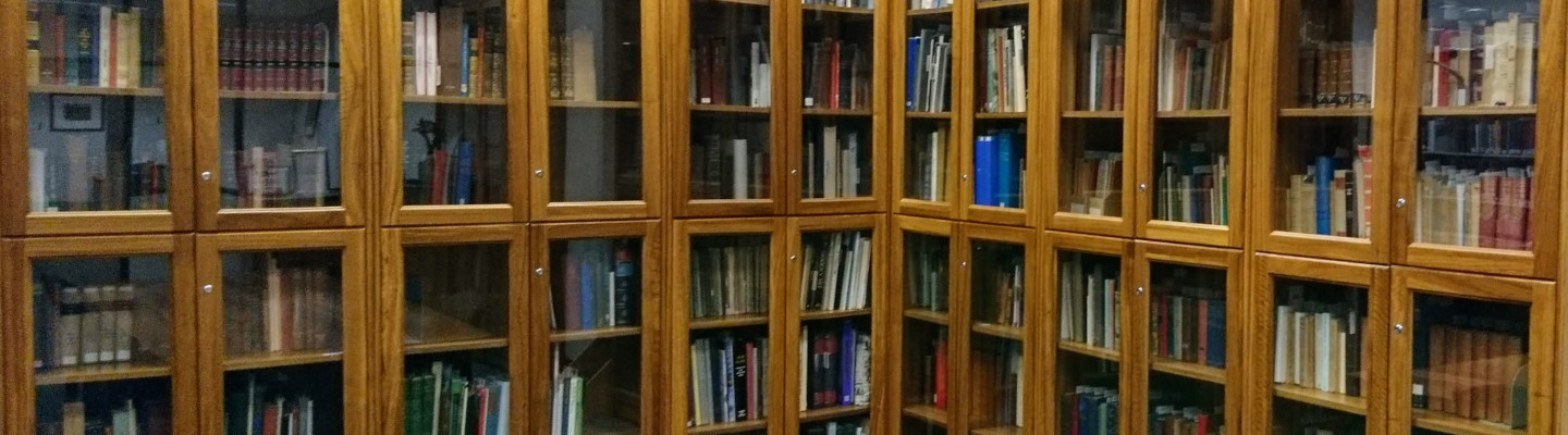 Two walls of wooden shelves and conference table in Archives Rare Book Room 