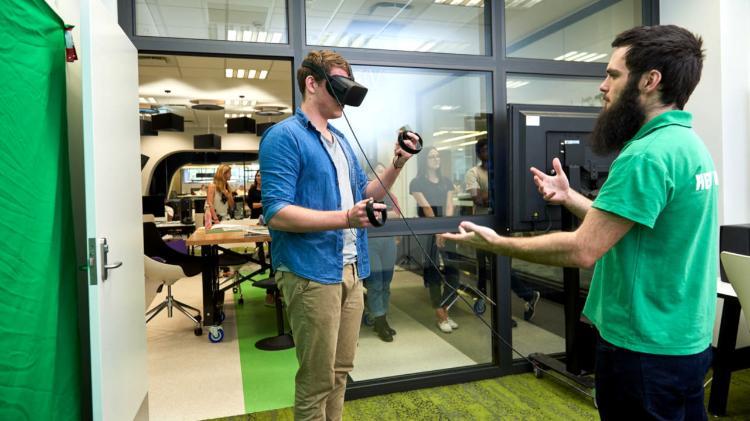 Staff member showing a student how to use virtual reality.