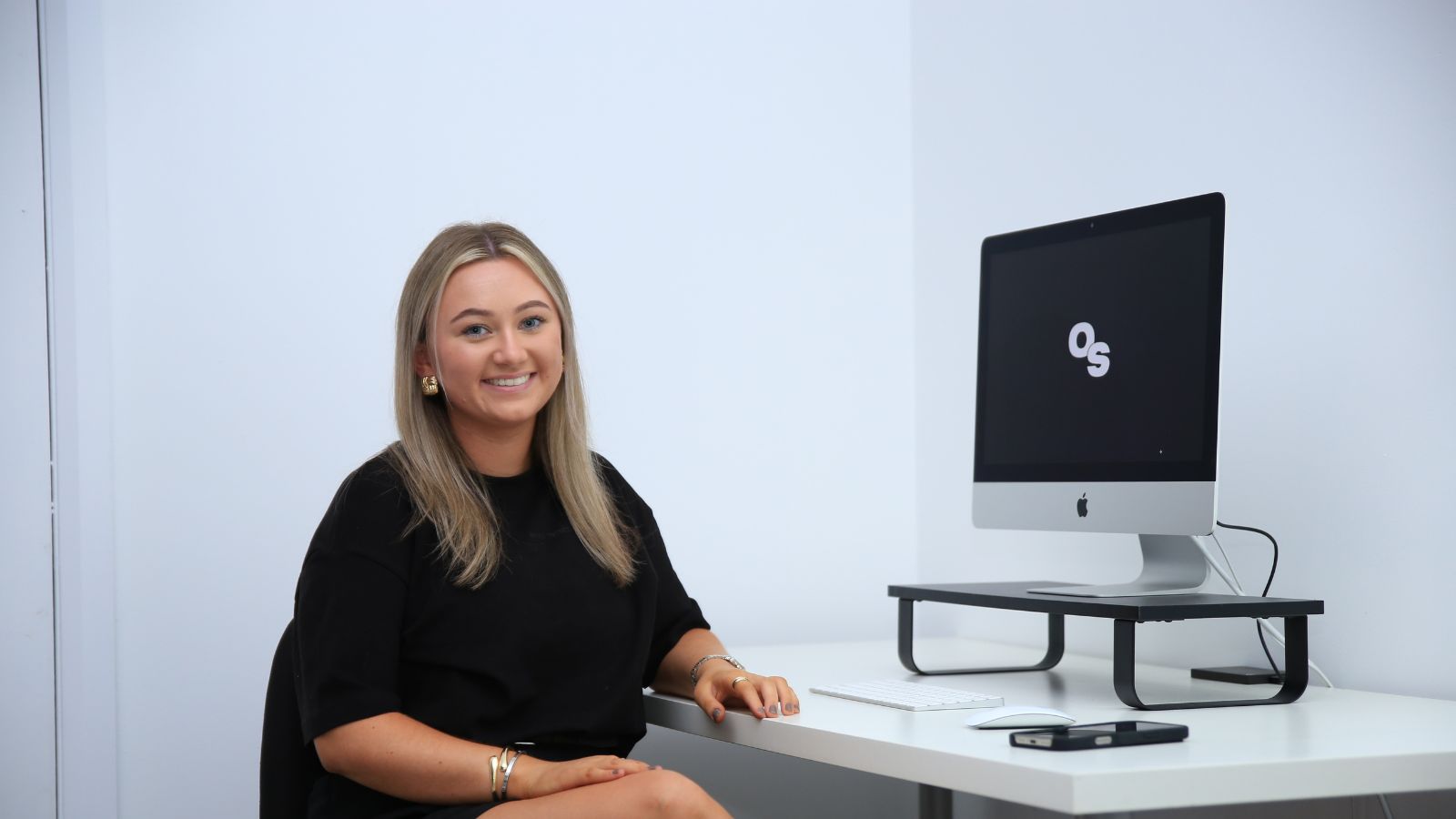 Charlotte smiling at camera in front of computer