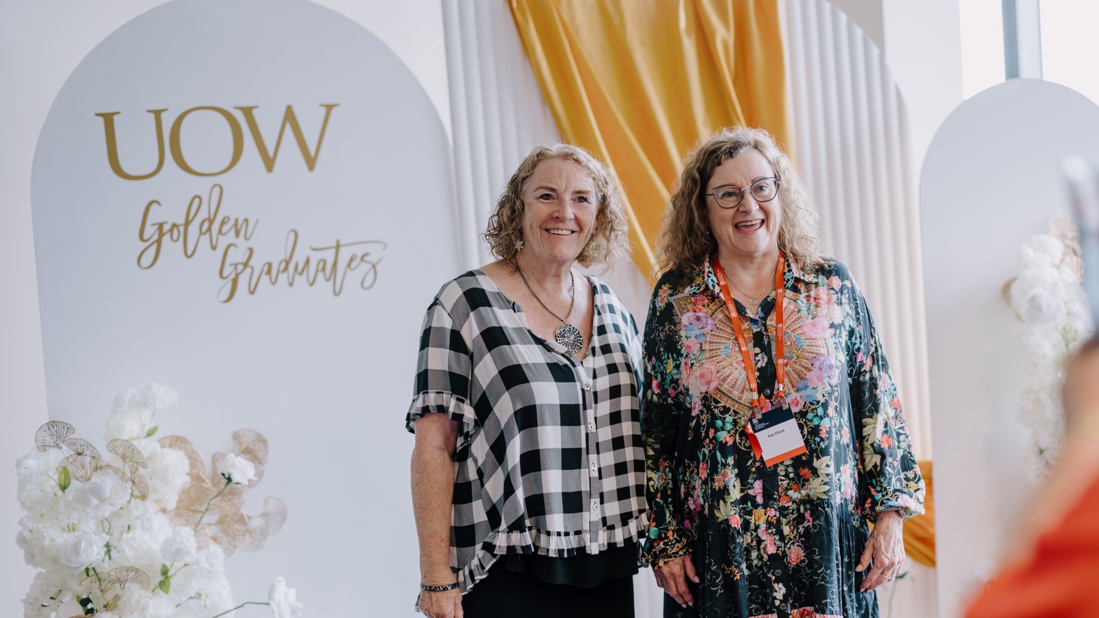 two ladies at the golden graduates dinner smiling at camera