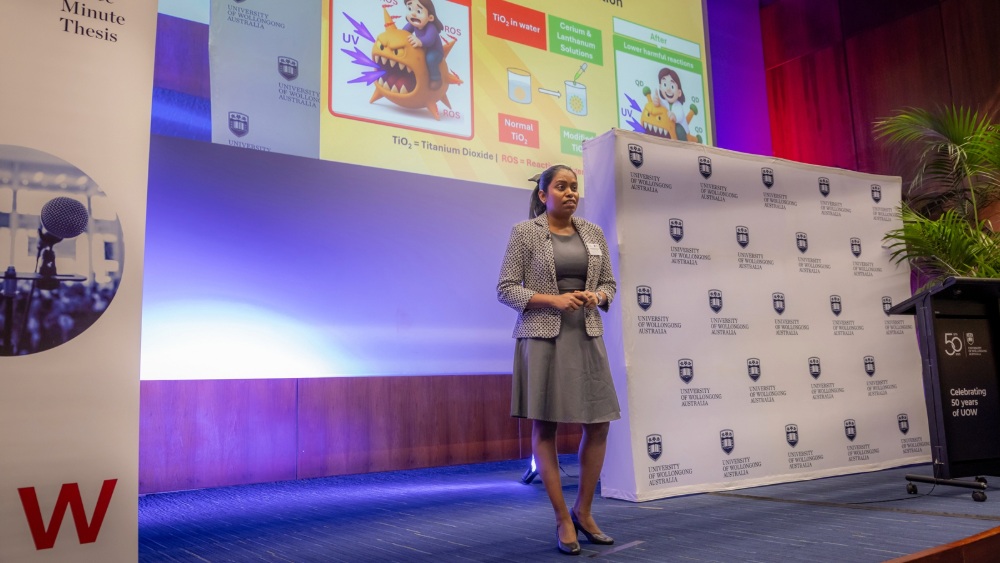 A woman presenting on a stage.