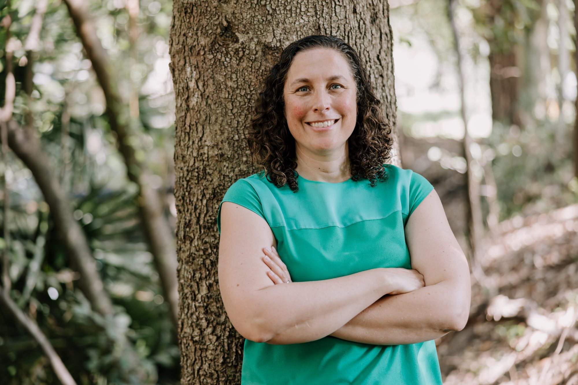 Associate Professor Sonia Graham arms folded, smiling at the camera, leaning against a tree. Photo: Michael Gray