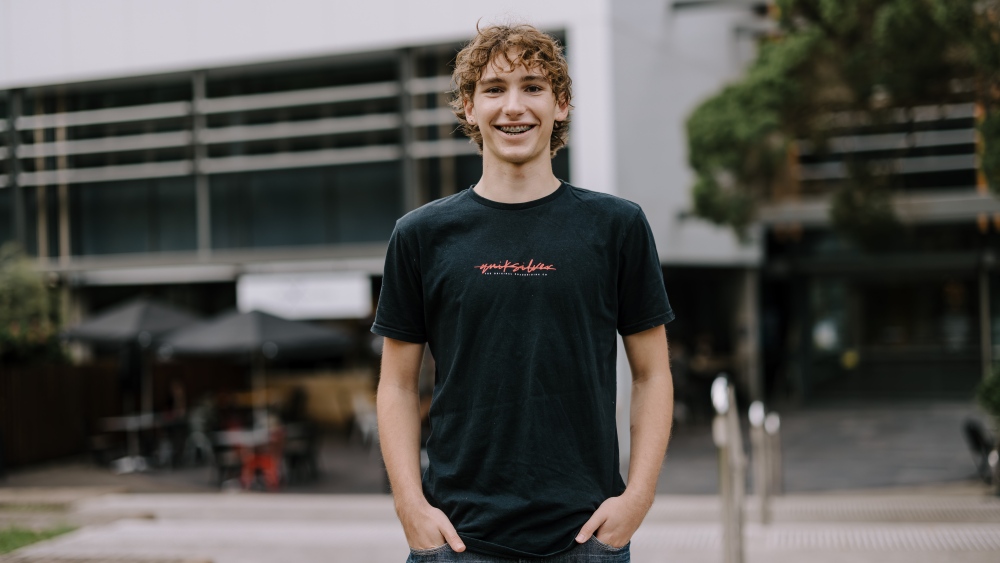 Student smiling in front of building