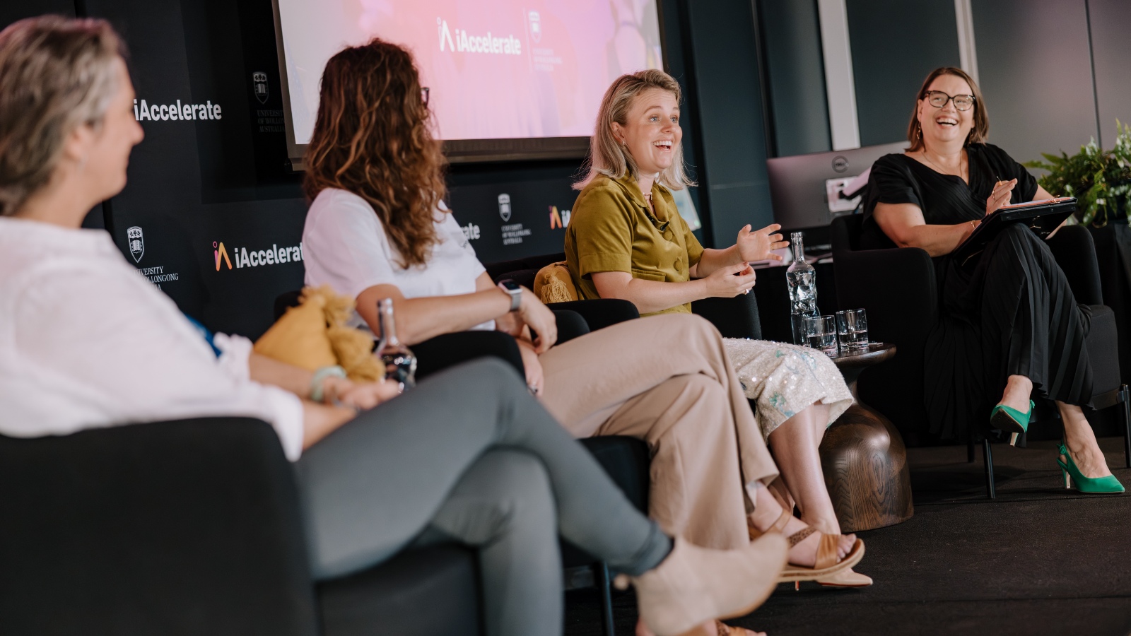 A panel of women at the iAccelerate Entrepreneurial Women's Breakfast laugh on stage during the event. Photo: Michael Gray