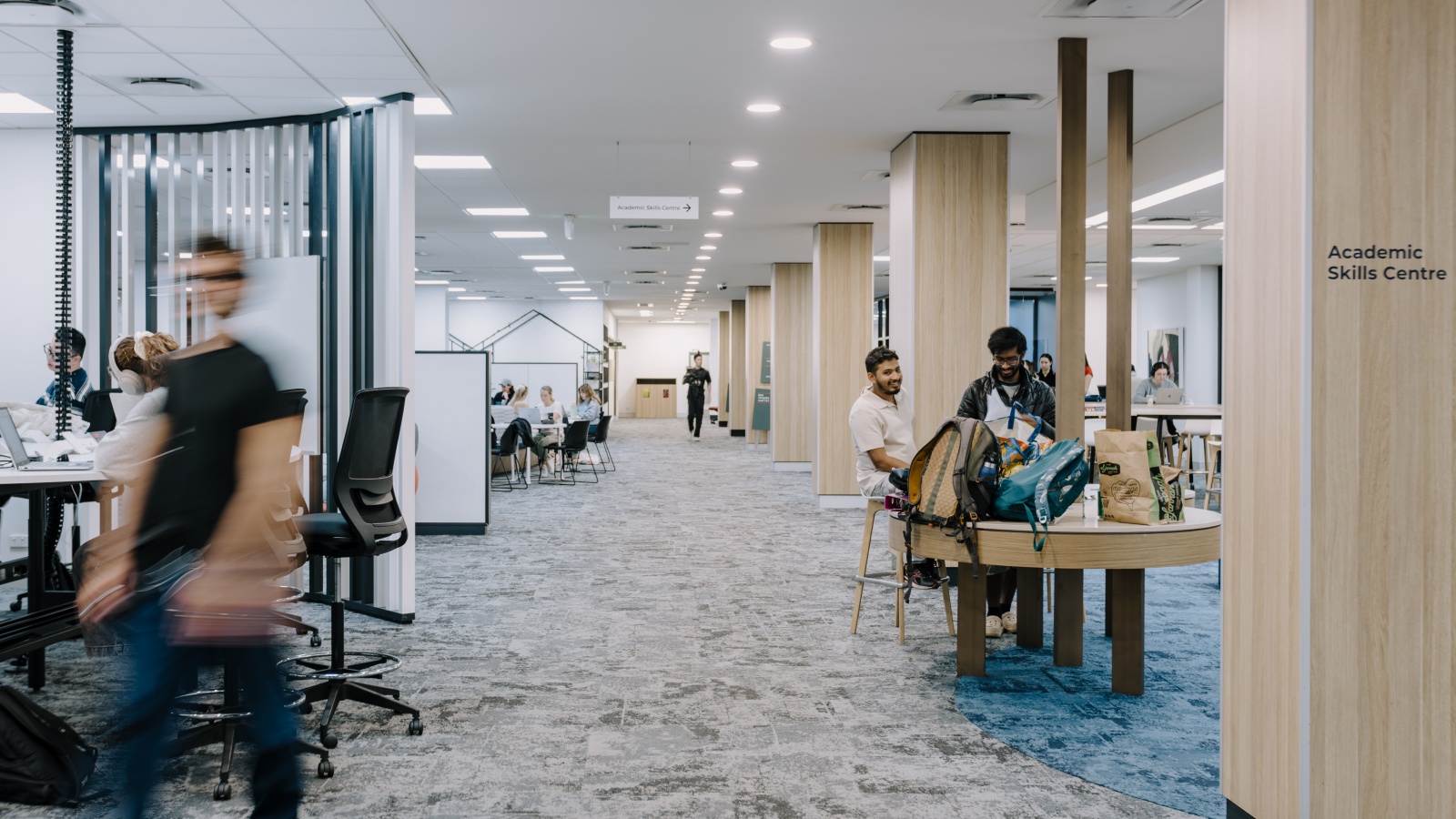 Students walking and sitting in the library
