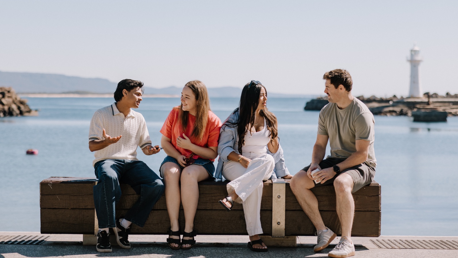 students sitting at Wollongong harbour talking