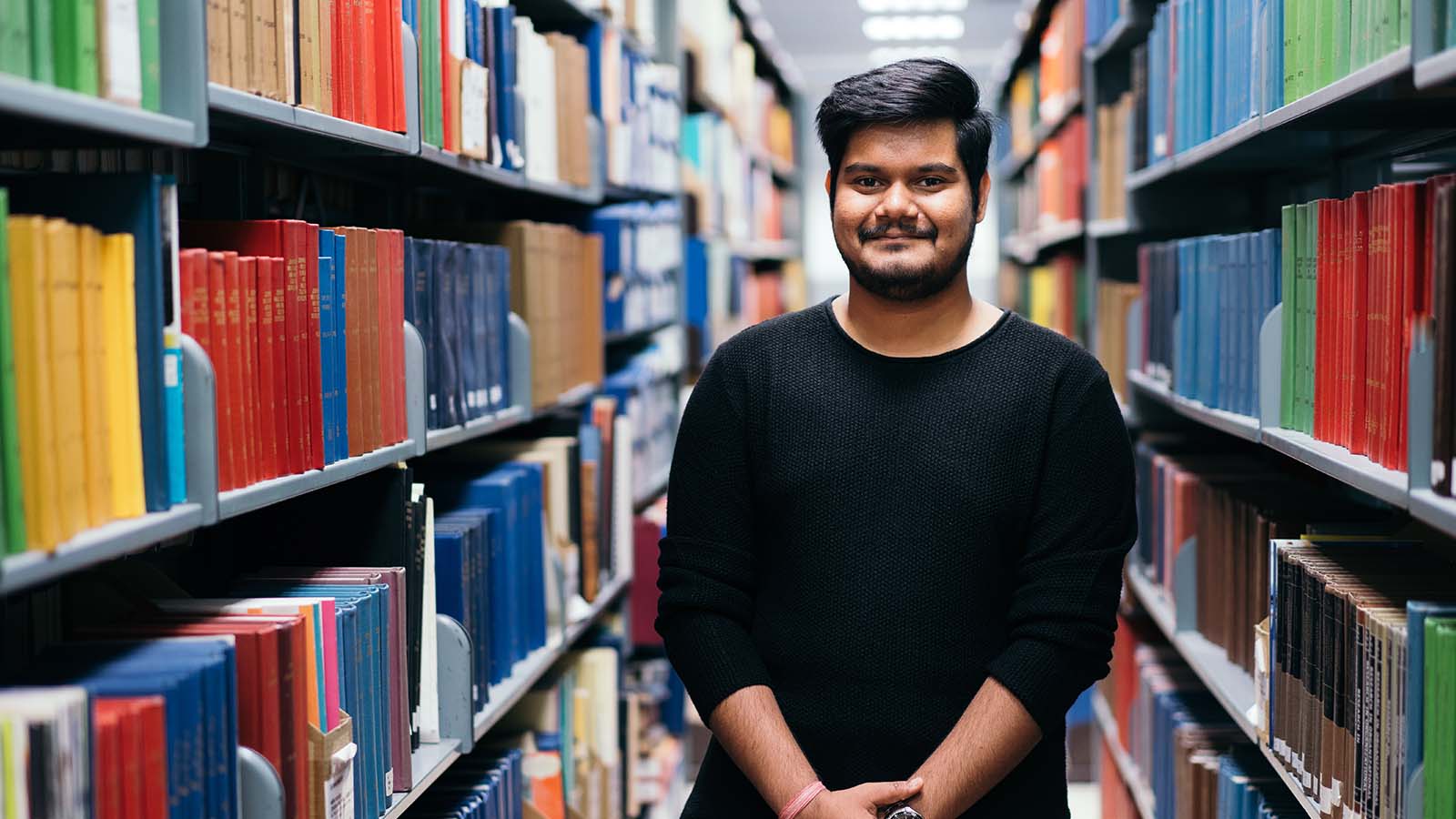 Shounak Das stands in the UOW Wollongong library