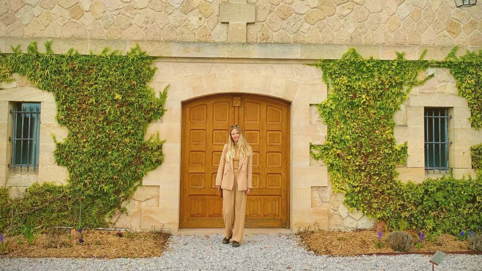 Girl standing in front of ivy clad farmhouse