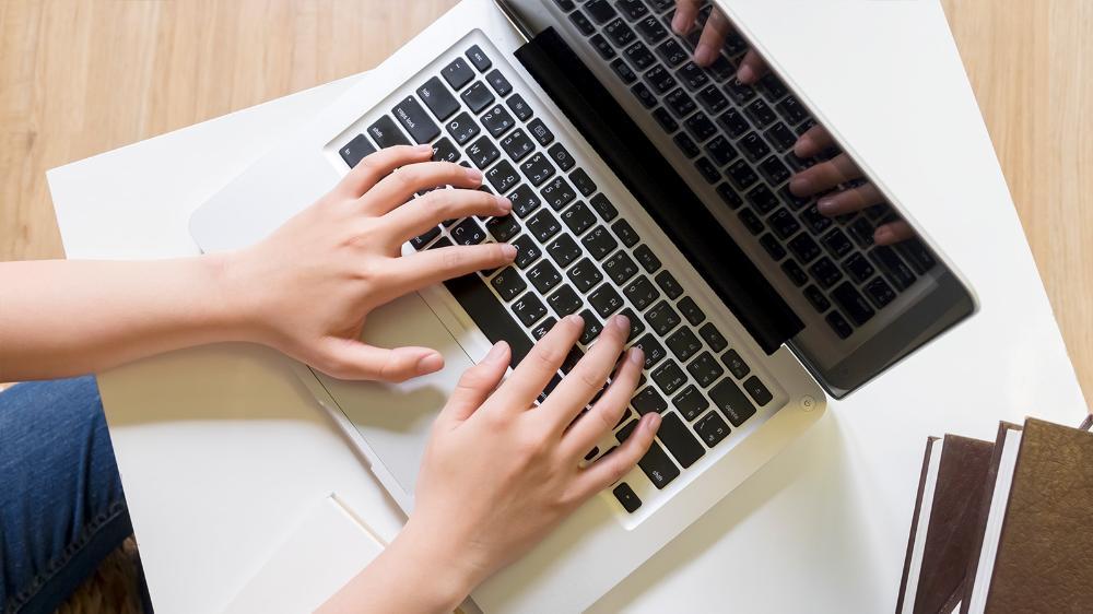 a student's hands on a laptop