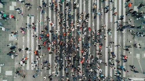 A crowd of people walk on the street