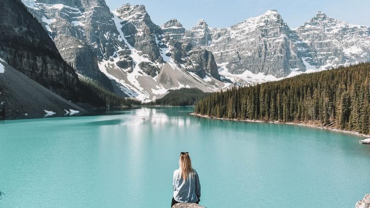 A student overlooks a lake and mountains