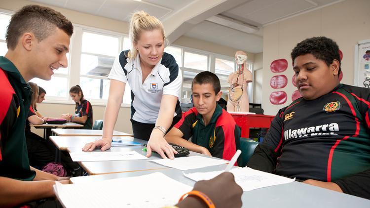 A UOW education student explains a task to a group of high school boys