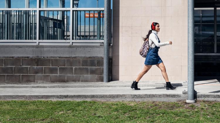 A student walking with purpose in front of North ý train station