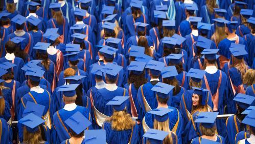 Back of head of graduating students sitting in graduation ceremony