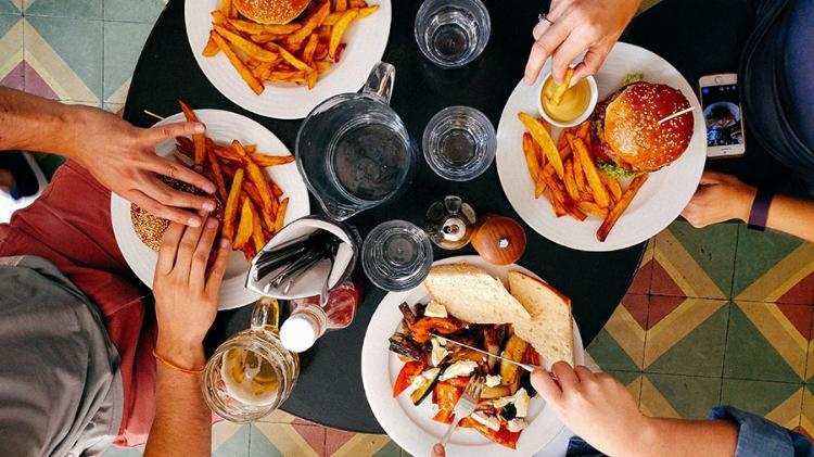 An overhead photograph of four people dining at a cafe.