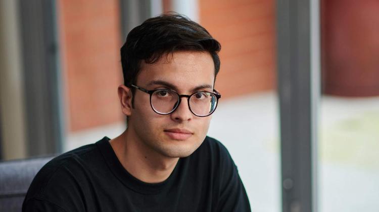 Male student wearing black tshirt and glasses