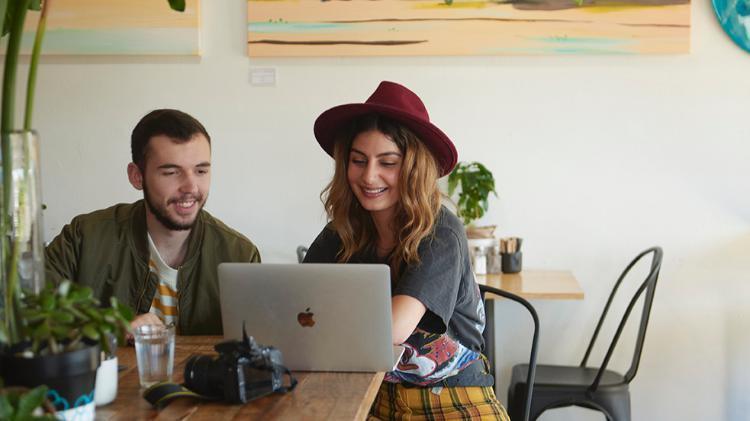 two students studying in a cafe with a laptop
