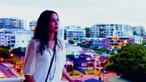 Student on balcony with Wollongong in the background