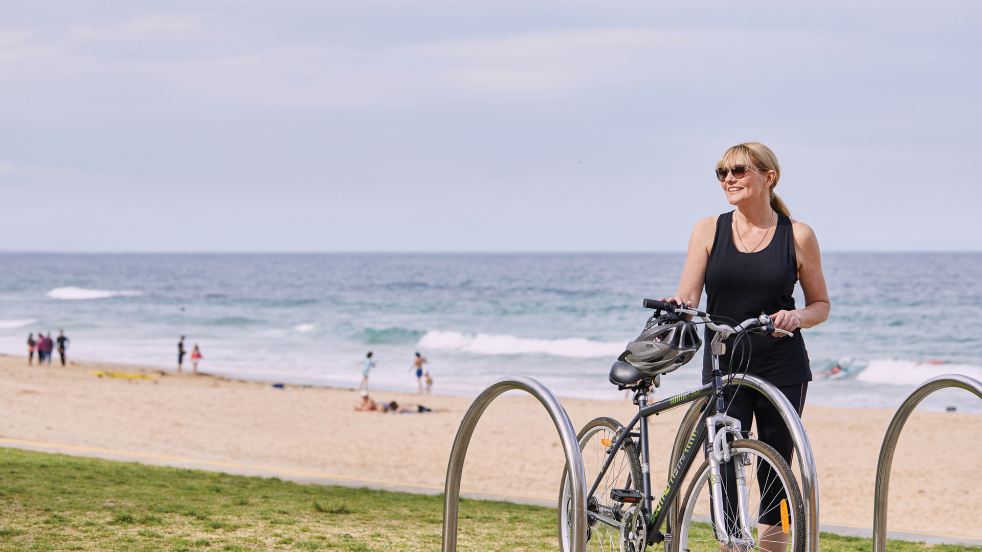 Woman riding bike at north wollongong beach 