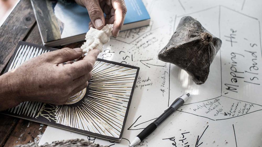 Sea shells, pens and paper.