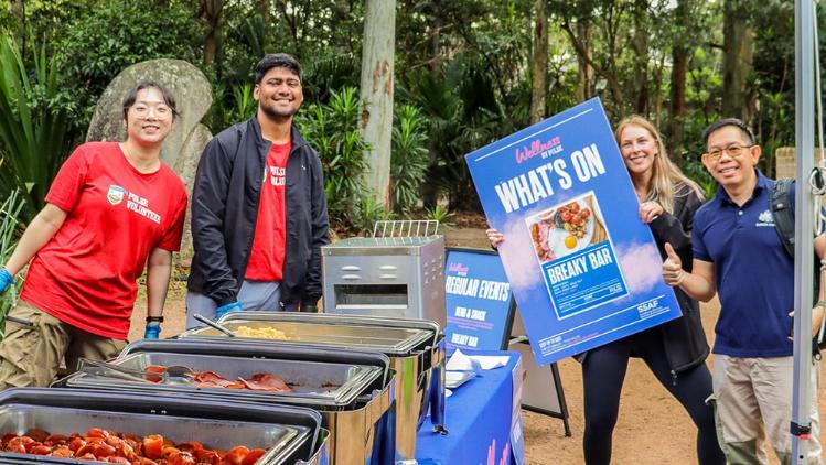 Students standing around a table with food on it