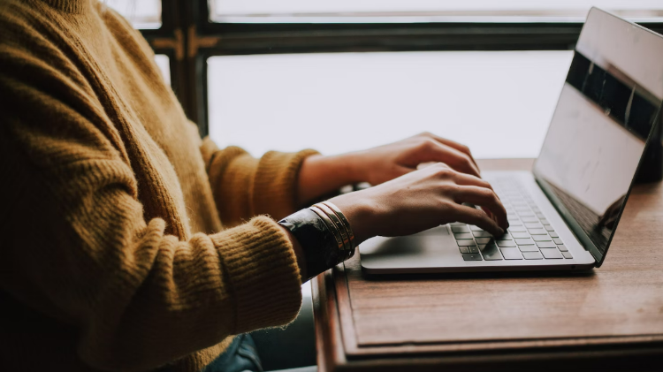 Student typing on laptop
