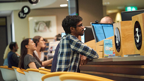 A student sitting at the enquiry counter at Student Central
