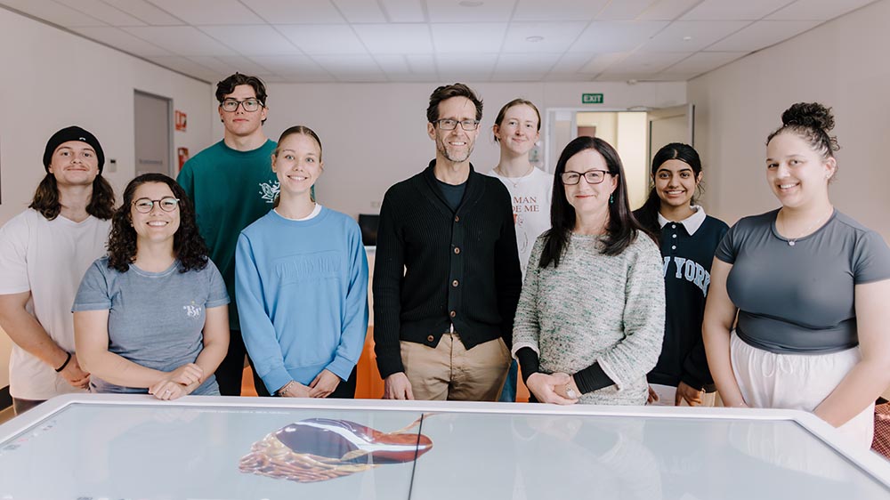 Students standing around a table