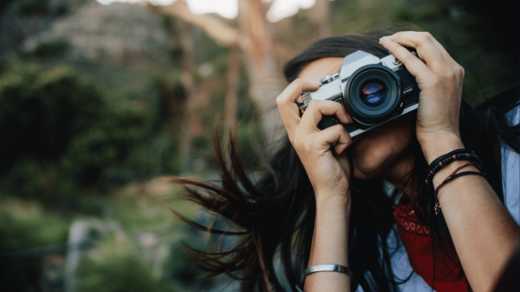 A student taking a photograph in nature