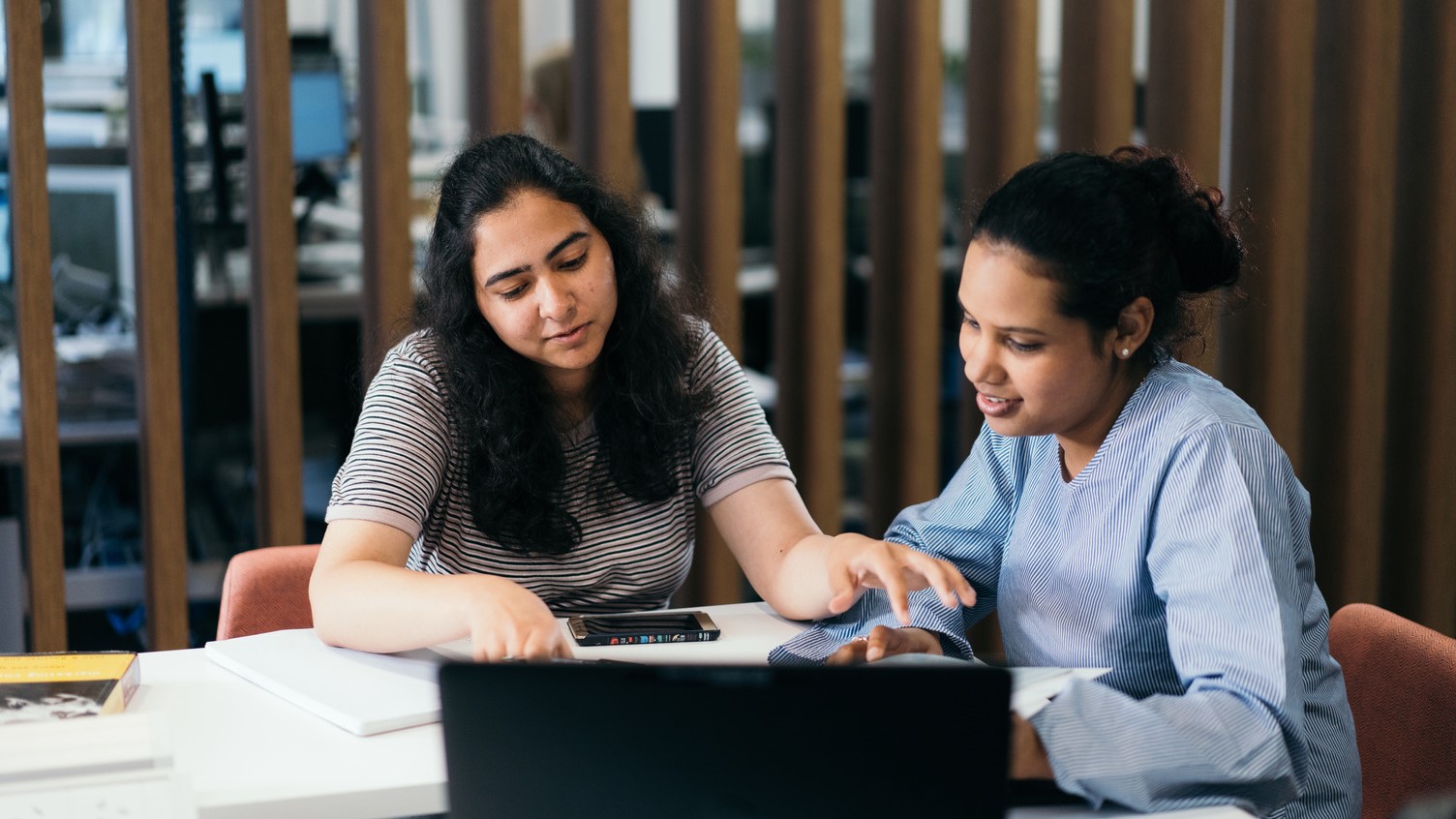 Two students sitting down studying together