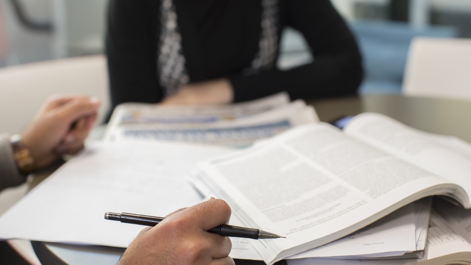 Two people going over a stack of documents