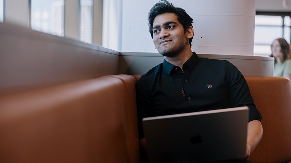 A student sitting on a lounge looking out a window