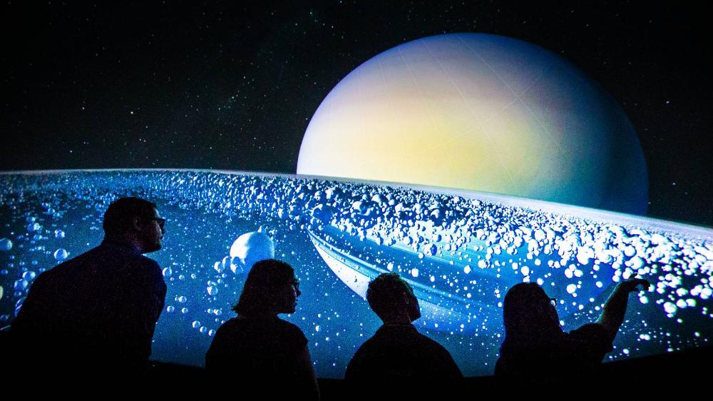 University of Wollongong Science Space Planetarium visitors gazing at the solar system display in the background